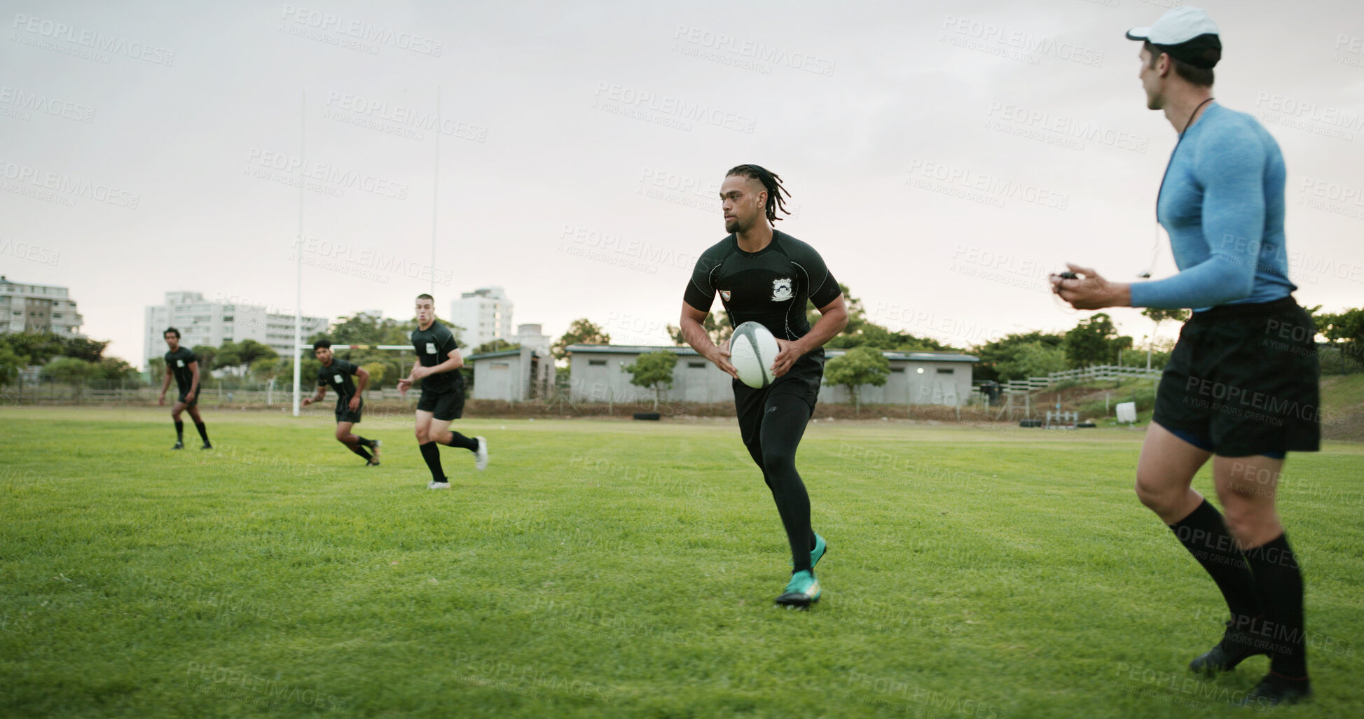 Buy stock photo Rugby, team and coach on field with practice, guidance and cardio exercise for competition outdoor. Instructor, men and running on grass with equipment, training and workout for sports performance.