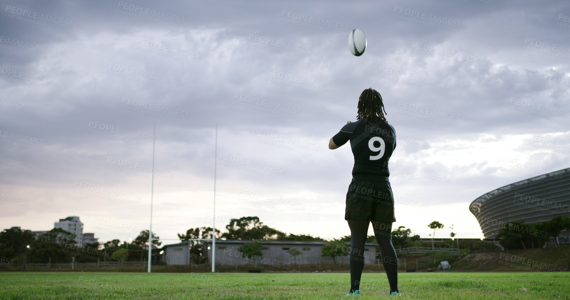 Buy stock photo Back, man and rugby player on field with ball, practice throwing technique or training for competition. Clouds, person and athlete outdoor with sports equipment, exercise and workout for fitness. 