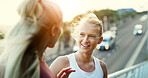 Happy, women or talking in city for fitness workout, outdoor exercise or training together. Female people, friends or chatting with smile, break or rest on bridge for health, wellness or conversation
