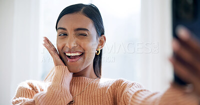 Buy stock photo Happy, home and Indian woman with wink for selfie, influencer post and web update for profile picture. Social media, smile and person with photography for online audience, playful and cute gesture