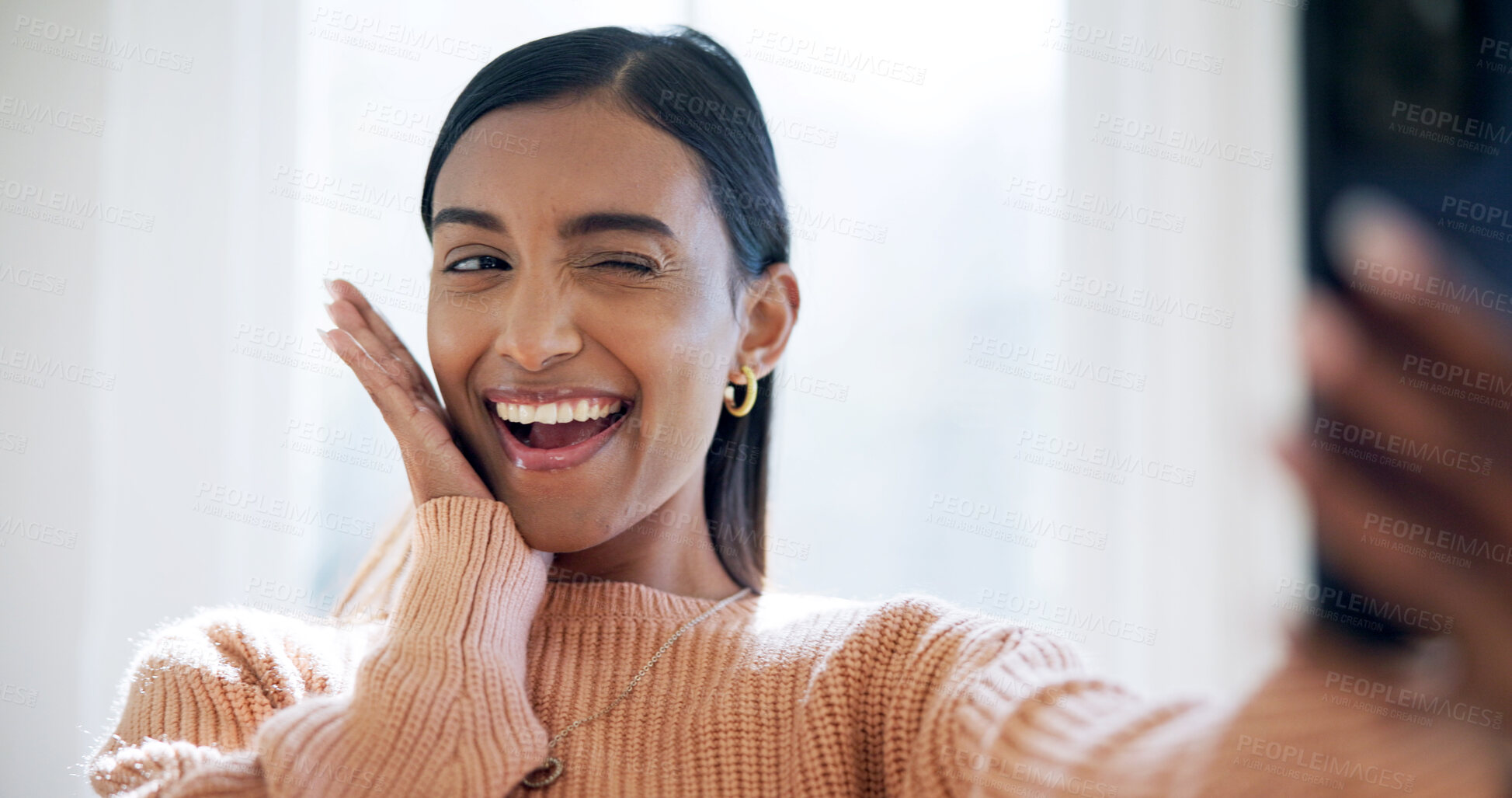 Buy stock photo Happy, home and Indian woman with wink for selfie, influencer post and web update for profile picture. Social media, smile and person with photography for online audience, playful and cute gesture