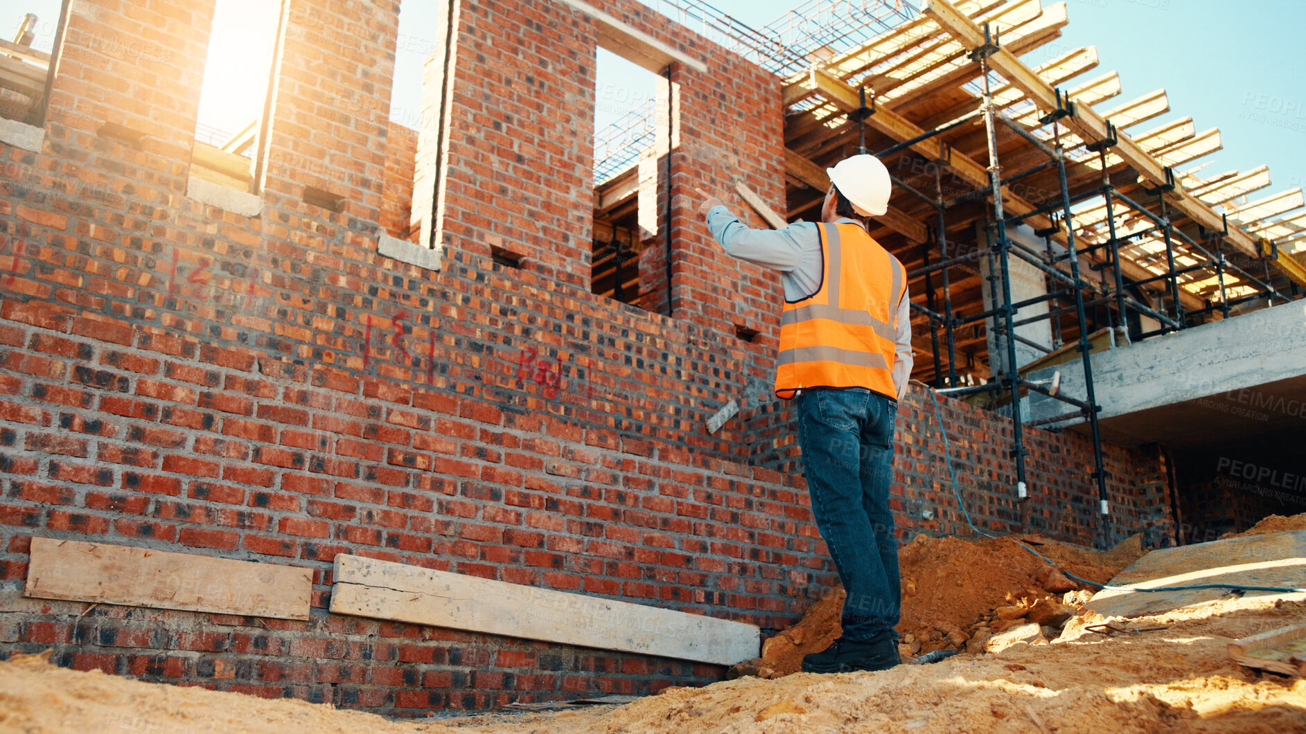 Buy stock photo Construction, point and man with building inspection for masonry safety, progress and compliance. Back, foreman or monitor development for defect management, quality control and outdoor on low angle
