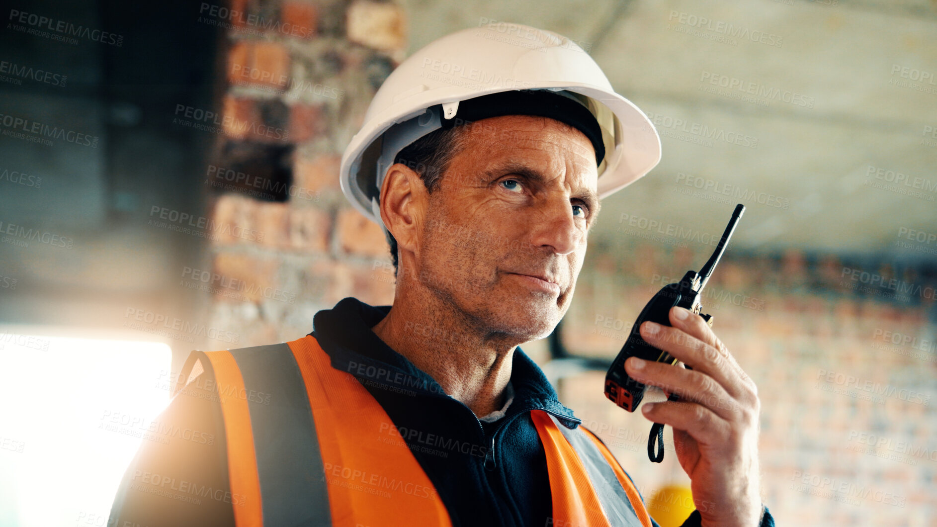 Buy stock photo Serious, architect and man with radio at construction site, listening and safety update for contact. Civil engineer, architecture and mature person with tech for discussion, quality assurance or chat