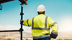 Planning, man and back of construction worker on site for inspection with building, repairs or maintenance. Outdoor, thinking and male civil engineer with infrastructure for industrial project.