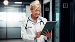 Hospital, doctor and mature woman on tablet for online consulting, patient report and telehealth. Healthcare, hallway and person on digital tech for research, medicare or schedule for medical service