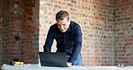 Man, laptop and architect at site with online design, blueprint or check schedule for building progress. Construction, foreman and pc to review digital floor plan, project management and renovation