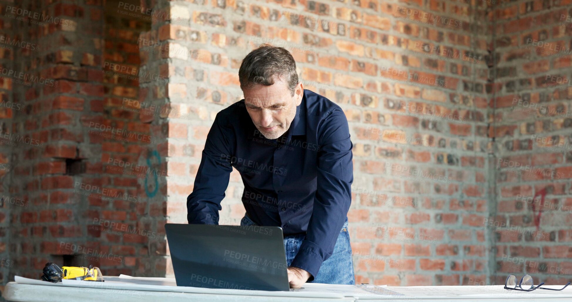 Buy stock photo Man, laptop and architect at site with online design, blueprint or check schedule for building progress. Construction, mature foreman and pc for digital floor plan, project management and renovation