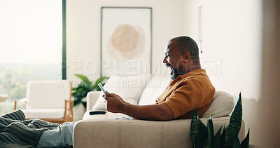 Buy stock photo Funny, phone and relax with black man on sofa in home living room for break or browsing. App, laughing and social media with mature person in apartment on weekend with joke, meme or online comedy
