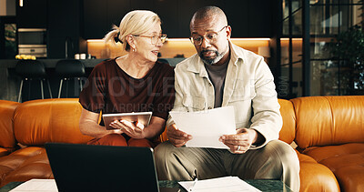 Buy stock photo Interracial couple, tablet and reading with documents in home for finance, bills or investment. Mature man, woman and paperwork with tech for financial planning, budget expenses or invoices together