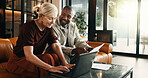 Interracial couple, laptop and smile with paperwork in home for mortgage, bills or investment. Mature man, woman and document with tech for financial planning, budget expenses or invoices together