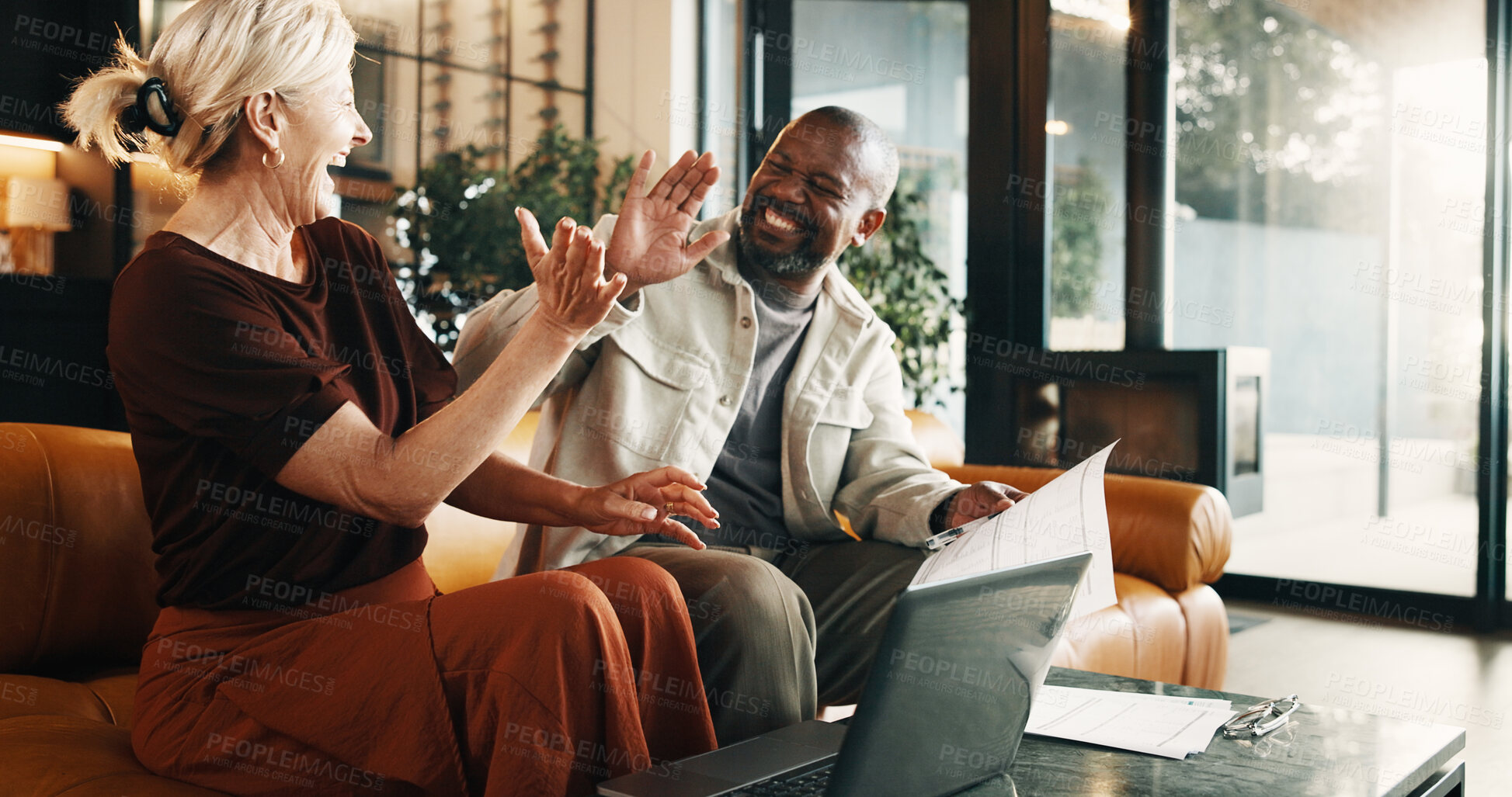 Buy stock photo Happy, finance and high five with document in home for budget success, winning or profit together. House, interracial couple and mature people with laptop for financial investment or good news