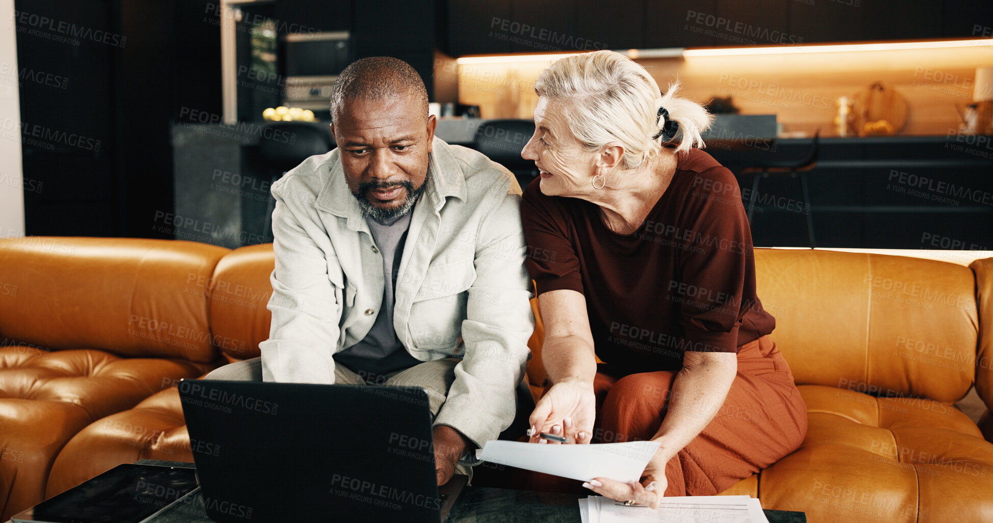 Buy stock photo Interracial couple, laptop and planning with document in house for mortgage, bills or investment. Mature man, woman and paperwork with tech for financial chat, budget expenses or invoices together