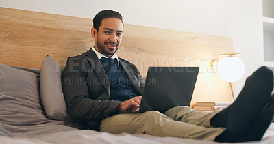 Buy stock photo Happy, man and relax in bedroom with laptop, social media and browsing website to unwind. Smile, male person and rest on bed at house with tech, streaming movies and watching video for weekend break