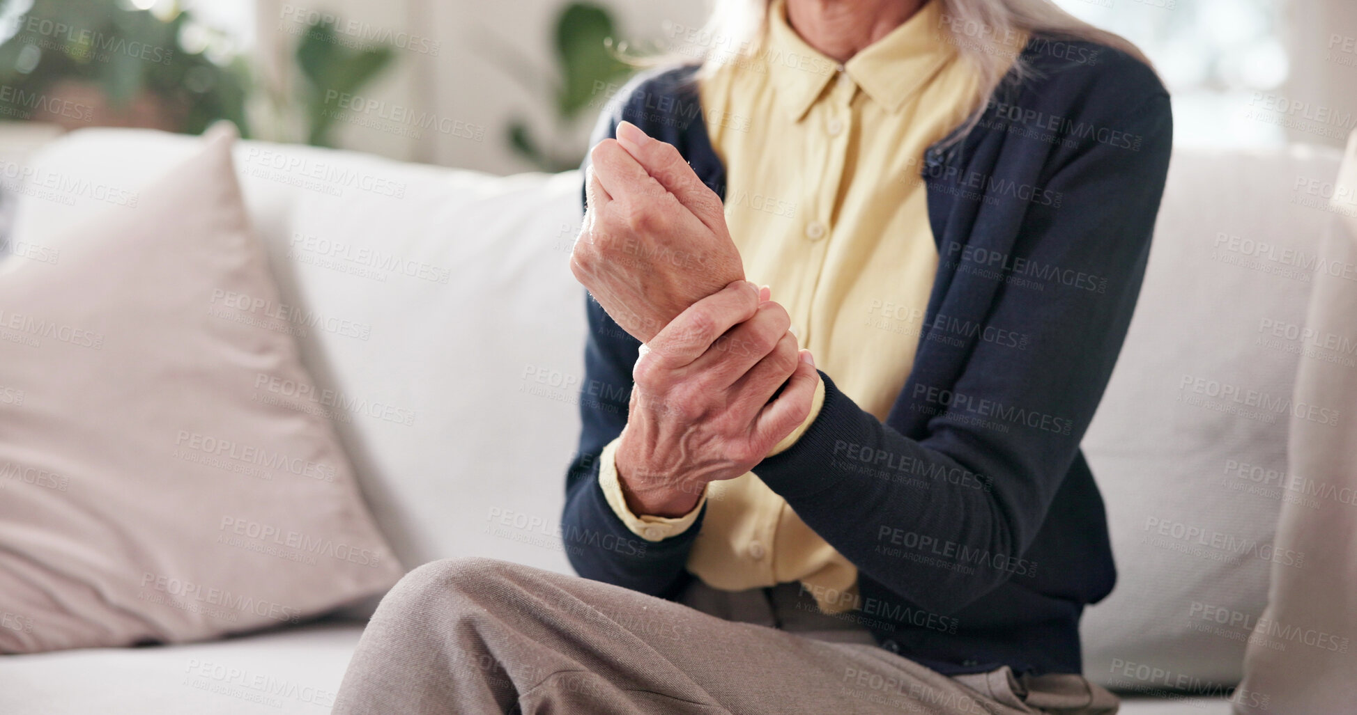 Buy stock photo Senior, woman and hands with wrist pain in home for joint inflammation or carpal tunnel syndrome. Elderly, female person or injury with sore arm on couch for arthritis, strain or muscle tension