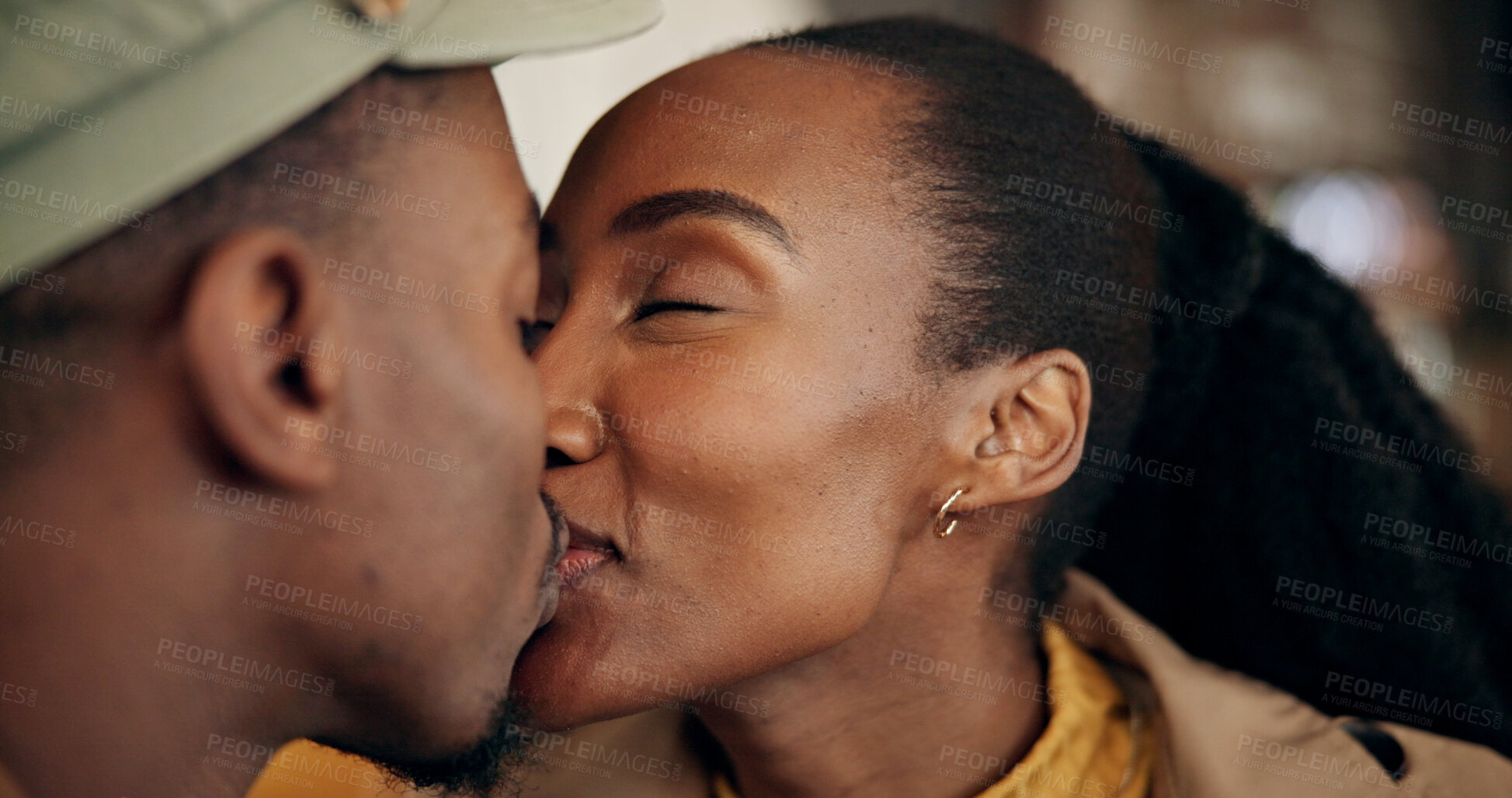 Buy stock photo Love, coffee shop and black couple with kiss on date for celebration, anniversary or honeymoon on holiday. Vacation, happy woman and man in restaurant for care, trust or support with romance together