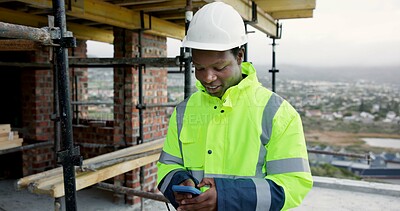 Buy stock photo Black man, typing and construction worker on site with phone for email feedback on renovation. Cellphone, smile and male civil engineer with texting for approval on building, maintenance or repairs.