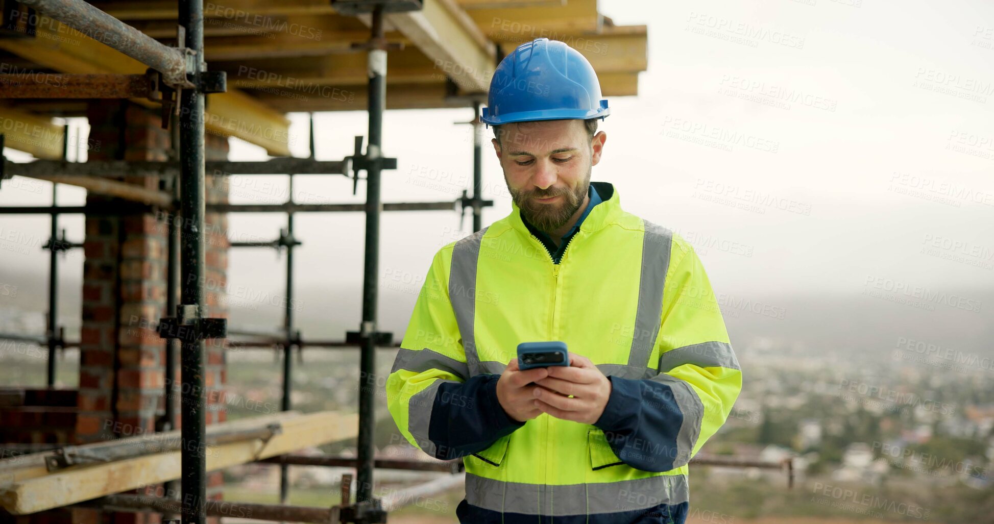 Buy stock photo Man, typing and construction worker on site with phone for email feedback on renovation. Cellphone, scaffolding and male civil engineer with texting for approval on building, maintenance or repairs.