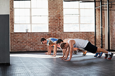 Buy stock photo Shot of a group of people doing some strength training in a fitness class