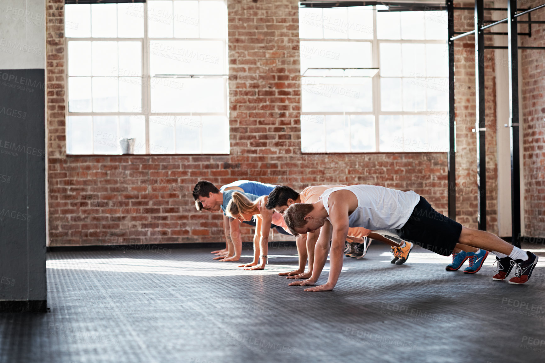 Buy stock photo Athlete, people and plank at gym for fitness, exercise and strength training with body balance. Strong, group and push up at facility with technique, core workout and endurance challenge for wellness