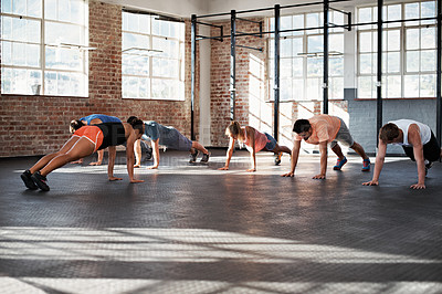 Buy stock photo Shot of a group of people doing some strength training in a fitness class 