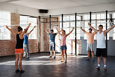 Buy stock photo Shot of a group of people doing a fitness class with bars