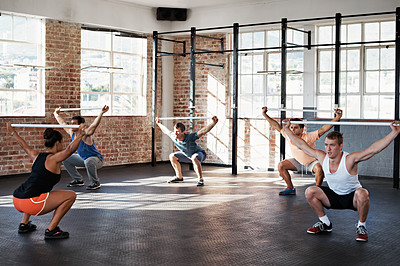 Buy stock photo Shot of a group of people doing a fitness class with bars