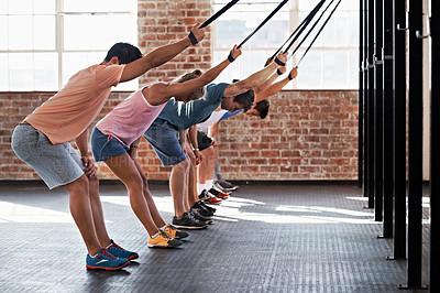 Buy stock photo Shot of a group of people using resistance bands in a crossfit class
