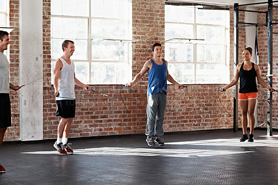 Buy stock photo Shot of a group of people jumping rope in a fitness class