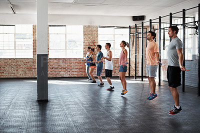 Buy stock photo Shot of a group of people jumping rope in a line in a fitness class