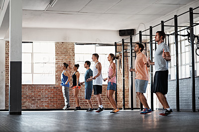 Buy stock photo Shot of a group of people jumping rope in a line in a fitness class