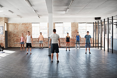 Buy stock photo Shot of a group of people doing a fitness workout with bars