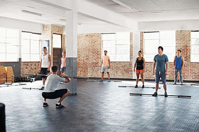 Buy stock photo Shot of a group of people doing a fitness workout with bars