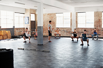Buy stock photo Shot of a group of people doing a fitness workout with bars