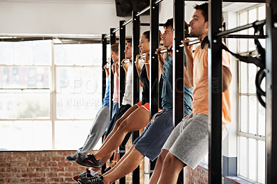 Buy stock photo Shot of a group of people doing pullups in a row in a fitness class