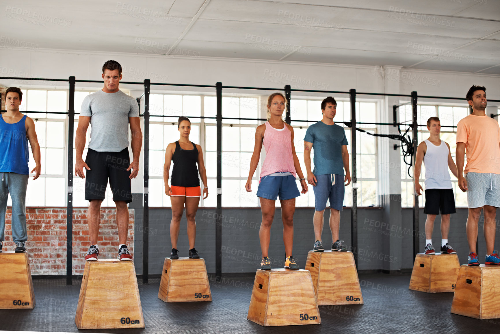 Buy stock photo Gym, people and serious fitness group on box for exercise, training and wellness in class together. Men, women and personal trainer at facility for workout, development and body health with equipment