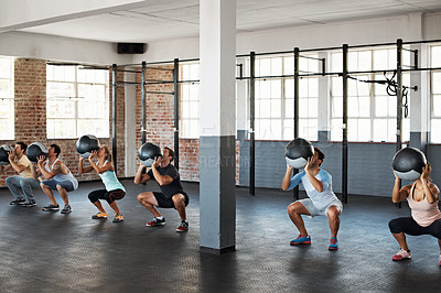 Buy stock photo Shot of a group of people doing a fitness class with medicine balls at a gym