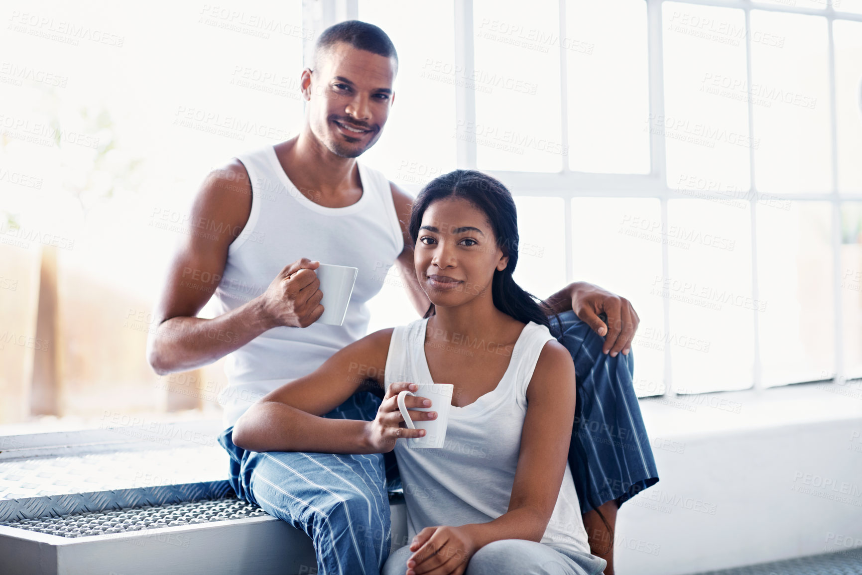 Buy stock photo African couple, morning and portrait with coffee by window for bonding, relationship or holiday together. Home, happy man and woman with beverage for comfort, support and care with weekend in house