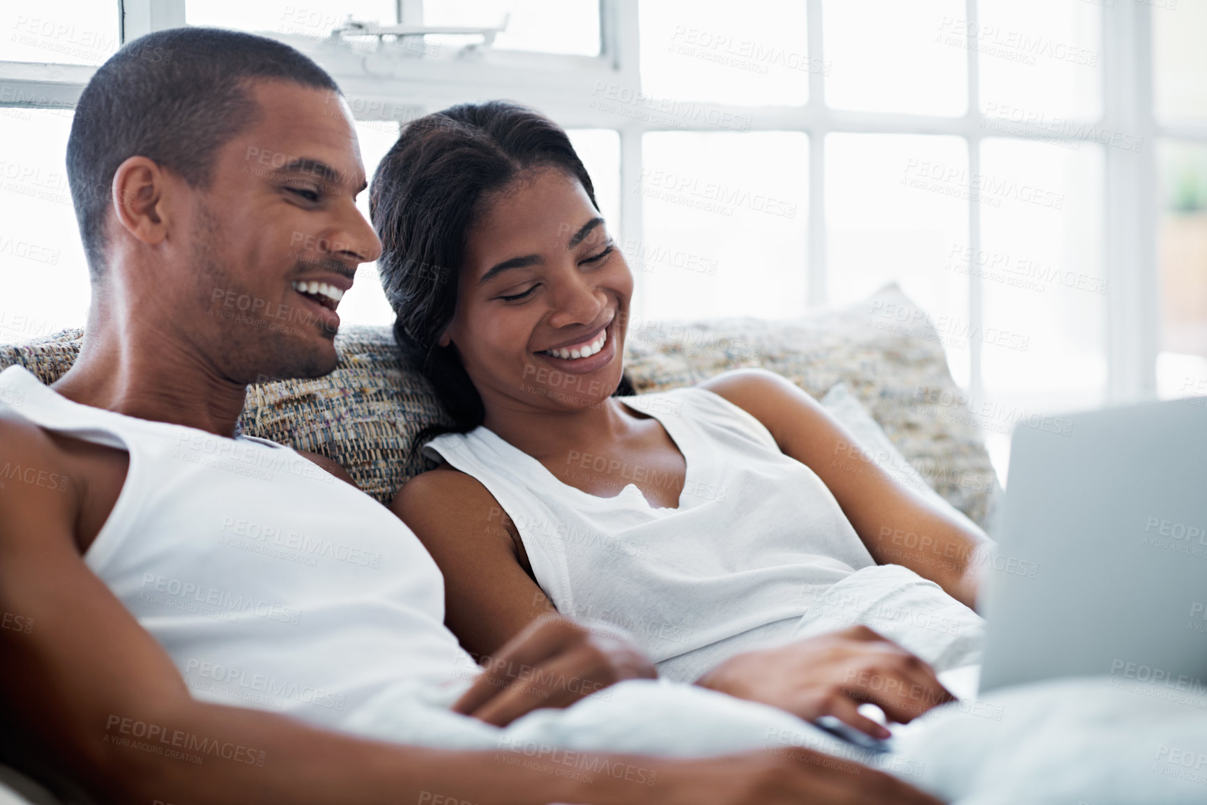 Buy stock photo Laptop, laugh and couple in bed at house watching movie, show or series for bonding together. Happy, technology and man with woman in bedroom on computer for streaming film with website subscription.