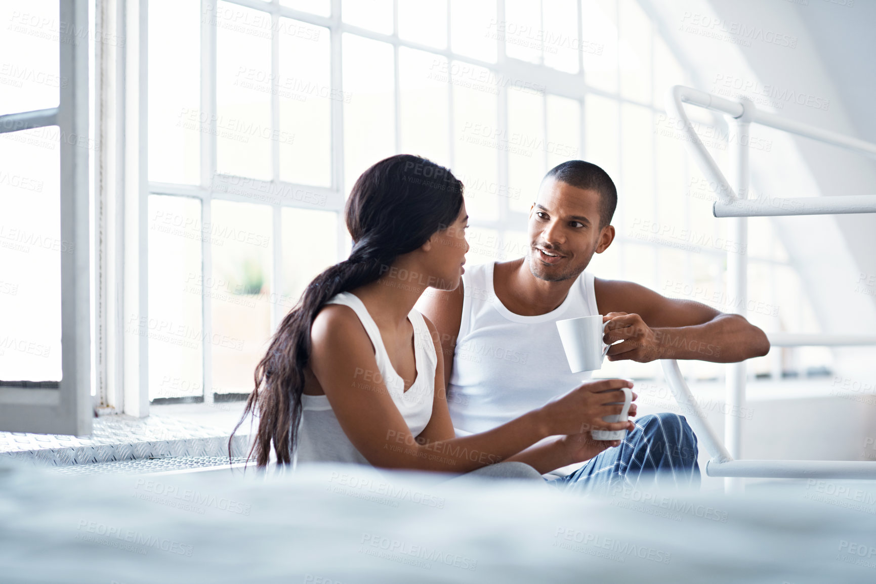 Buy stock photo Talking, happy and couple with drink in home for bonding, conversation and relationship in morning. Weekend, house and man with woman for connection, communication and coffee for love, trust and chat