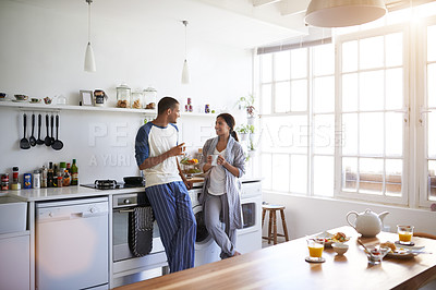 Buy stock photo Cropped shot of a young couple having breakfast in the kitchen