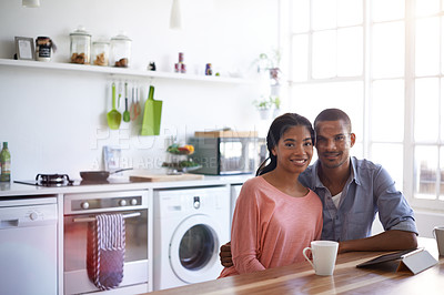 Buy stock photo Cropped portrait of a young couple drinking coffee and using their tablet in the kitchen