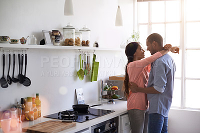 Buy stock photo Cropped shot of an affectionate young couple hugging in the kitchen