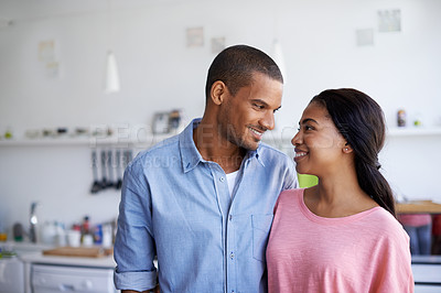 Buy stock photo Cropped shot of a young couple standing face to face in the kitchen