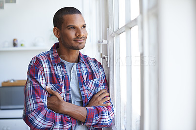 Buy stock photo Cropped shot of a young man looking out of the kitchen window