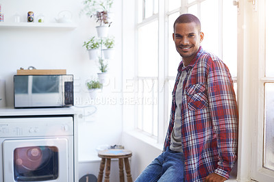 Buy stock photo Cropped portrait of a young man standing by the kitchen window