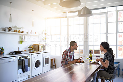 Buy stock photo Cropped shot of a young couple eating dinner in their kitchen