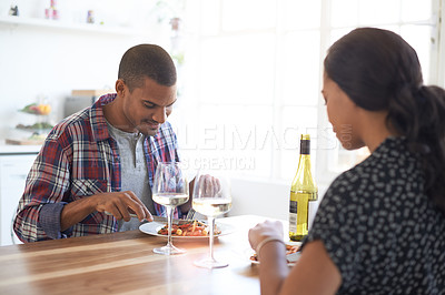 Buy stock photo Cropped shot of a young couple eating dinner in their kitchen