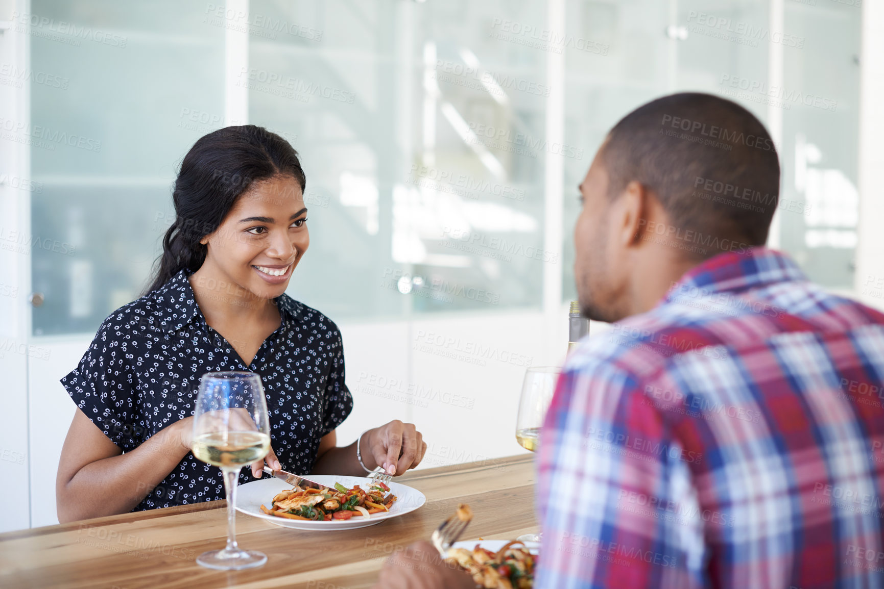 Buy stock photo Cropped shot of a young couple eating dinner in their kitchen