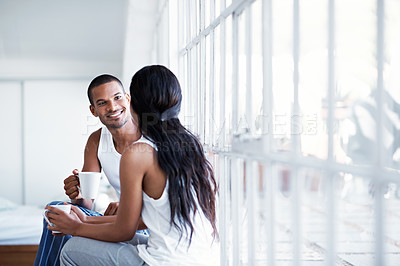 Buy stock photo Shot of a young couple talking together while sitting in their bedroom
