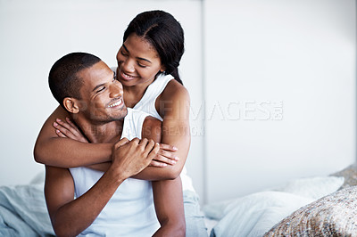 Buy stock photo Shot of a woman hugging her husband from behind while sitting on their bed